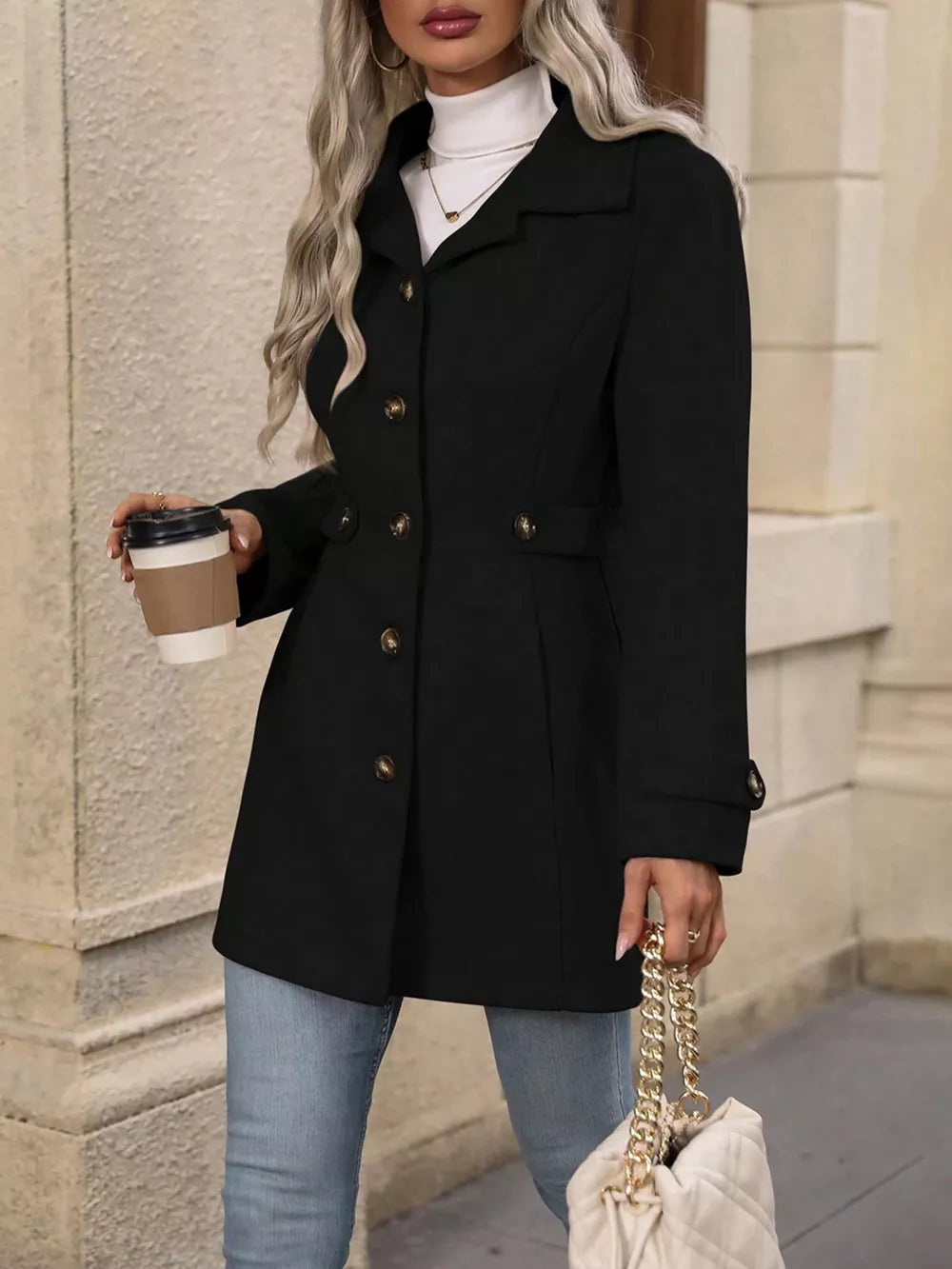 Black button-up trench coat with cinched waist and gold buttons, worn with jeans.