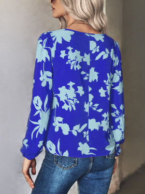 Royal blue floral tie-neck blouse with long sleeves and a relaxed fit.