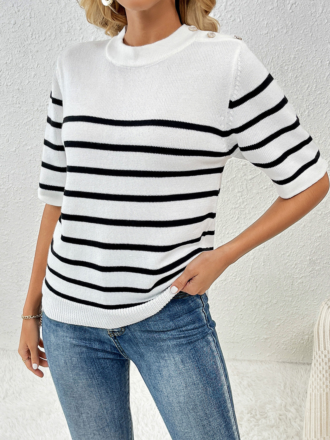 White and black striped knit top with button shoulder detail and short sleeves.