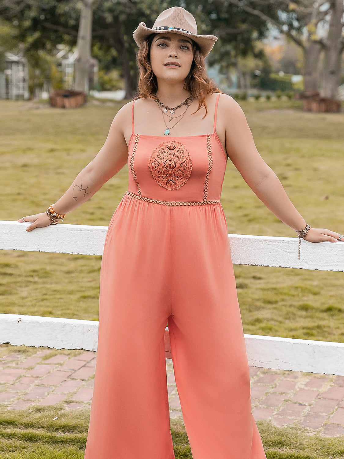 Orange wide leg jumpsuit with embroidered bodice and chain trim detail.
