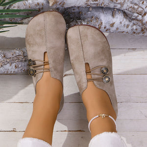 Light brown round-toe casual flats with decorative buttons and elastic straps.