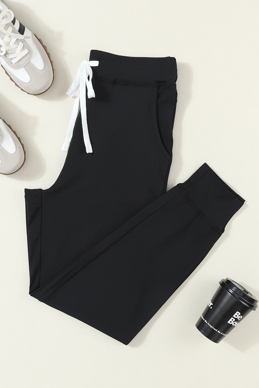 Black slim-fit joggers with drawstring and cuffed ankles.
