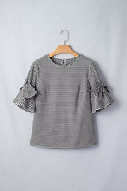 Black and white gingham polyester shirt with ruffled bow tie sleeves.