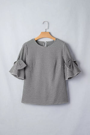 Black and white gingham polyester shirt with ruffled bow tie sleeves.