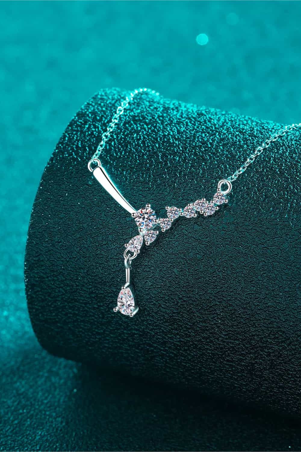 Silver asymmetrical moissanite cluster pendant necklace with a teardrop accent.