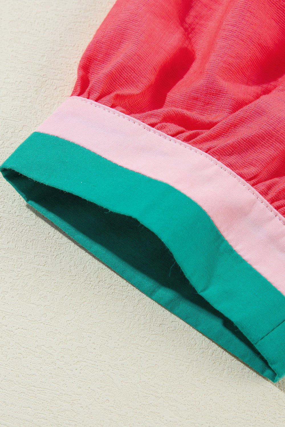 Colorblock puff sleeve blouse in strawberry pink with green and pink trim detail.