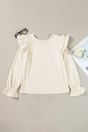 Eggshell textured blouse with ruffle sleeves and cuffs.