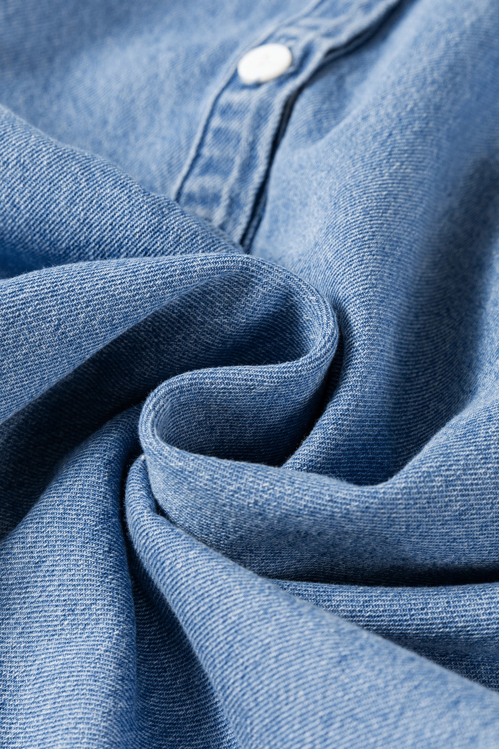 Light blue denim blouse with ruffled collar detail and button closure
