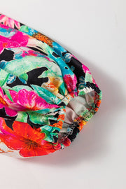 Vibrant floral print blouse with gathered elastic cuff and colorful tassel trim detail.