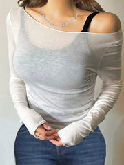 White sheer long sleeve t-shirt with boat neck, worn with a black bra and necklace.