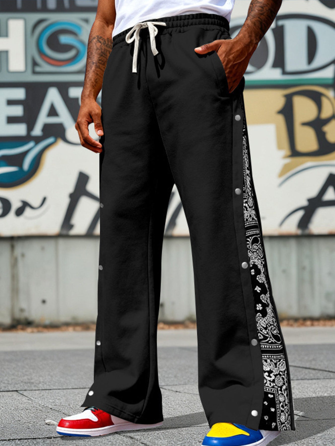 Black wide leg sweatpants with drawstring and side snaps featuring bandana print detail.