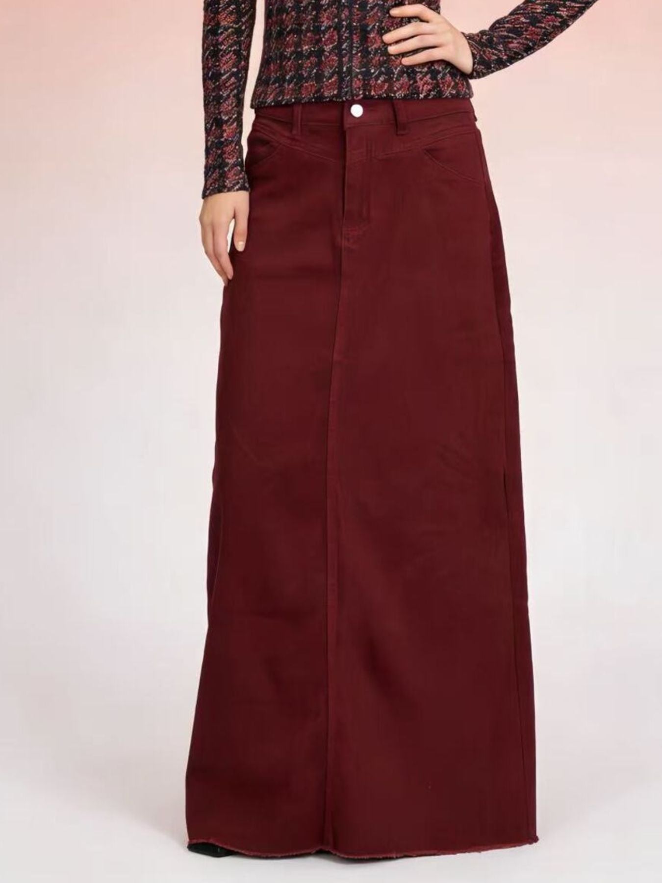Burgundy cotton maxi denim skirt with raw hem and button closure.