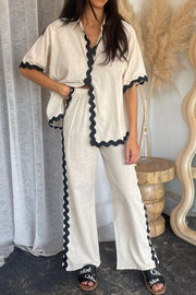 Beige linen shirt and pant set with black scalloped trim detail.