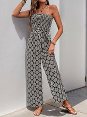 Black geometric print bandeau jumpsuit with smocked bodice, button detail, and tie belt.