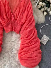 Orange ruched sleeve blouse with deep V-neck and smocked waist detail.