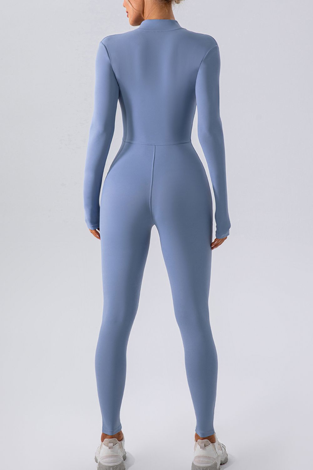 Light blue zip-front bodycon jumpsuit with long sleeves and high neckline.