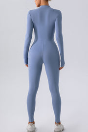 Light blue zip-front bodycon jumpsuit with long sleeves and high neckline.