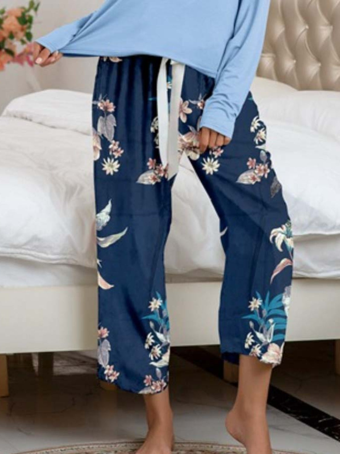 Botanical print lounge pants in dark blue with white tie waist and light blue long sleeve top.