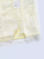Lace-trimmed midi slip dress in pale yellow with a side slit and delicate lace hem.