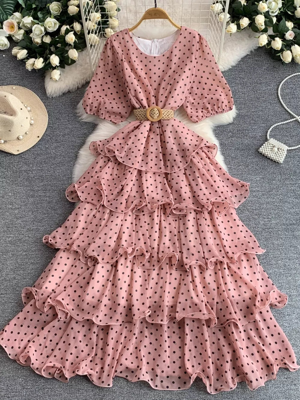 Pink polka dot tiered chiffon dress with puff sleeves and a woven belt.
