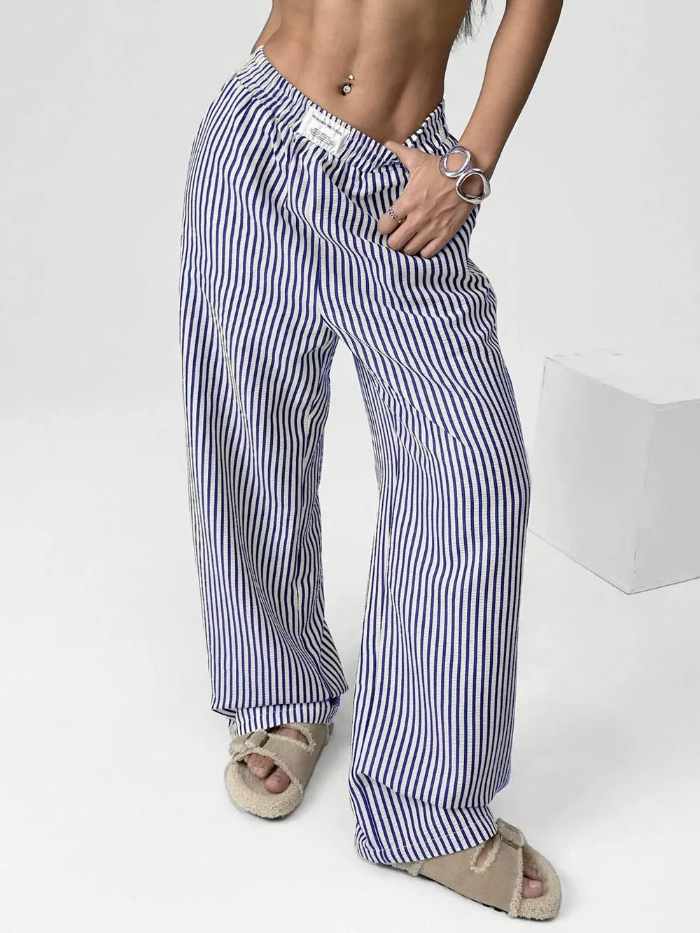 Navy striped high-waisted wide-leg pants with drawstring detail.