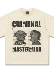 Pastel yellow cotton t-shirt with a bold cartoon graphic of two mugshot portraits and the text Criminal Mastermind.