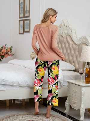 Botanical print lounge set with long sleeve top in dusty pink and cropped pants in vibrant floral pattern.