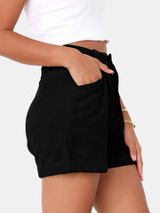 Black corduroy high-waist pleated shorts with cuffed hem and pockets.