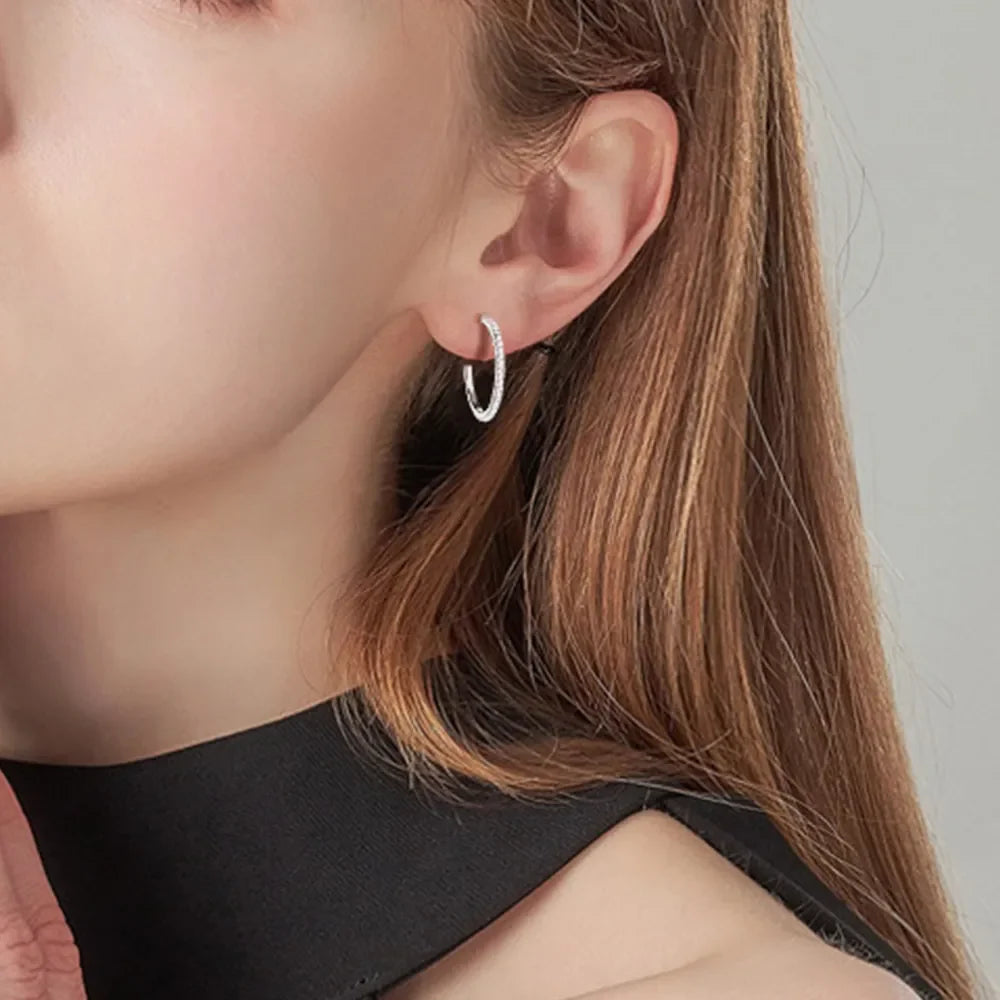 Silver pavé-set C-hoop earrings with textured detail.