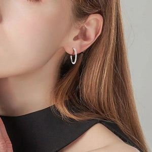 Silver pavé-set C-hoop earrings with textured detail.