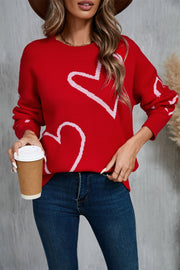 Red acrylic knit jumper with white outline hearts, crew neck, long sleeves.