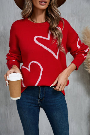 Red acrylic knit jumper with white outline hearts, crew neck, long sleeves.