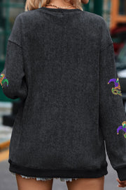 Black ribbed knit tunic with Mardi Gras mask embellishments on sleeves.