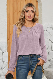 Lilac knit top with pleated yoke and ruffled cuffs, crew neck, long sleeves.