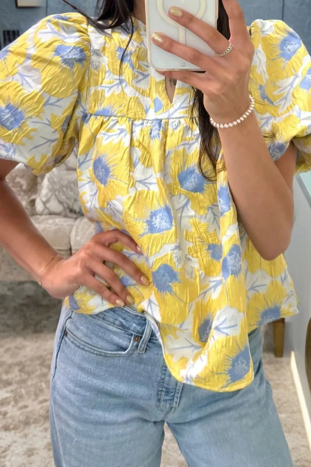 Yellow floral textured blouse with bubble sleeves and V-neck.
