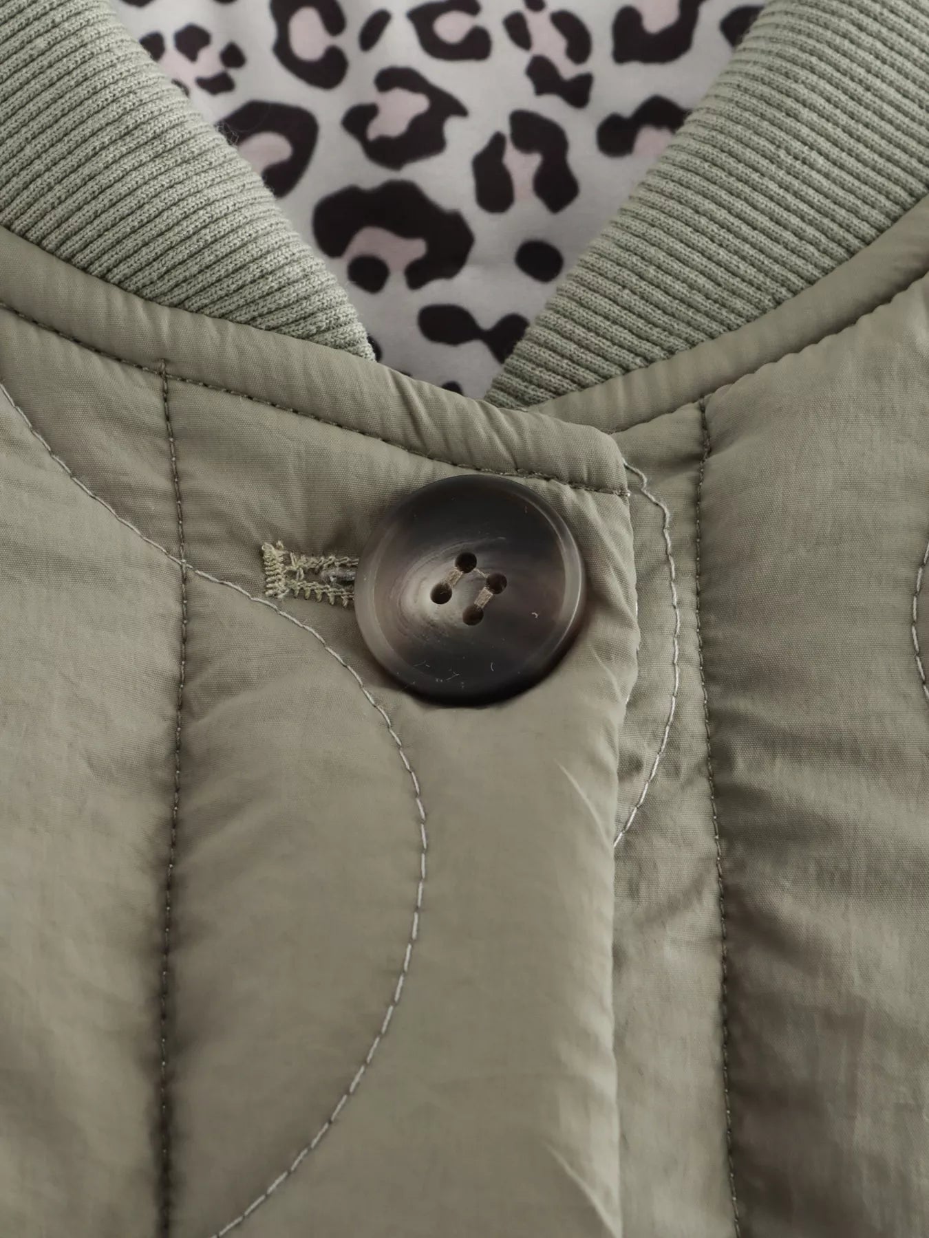 Lined quilted button-down jacket in moss with leopard print lining and ribbed collar.