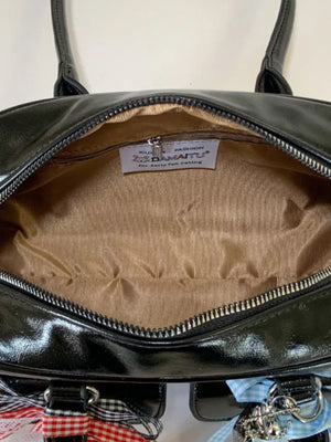 Black patent shoulder bag with ribbon embellishments and charms
