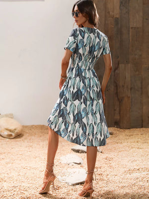 Vibrant leaf pattern midi dress with smocked waist and short sleeves in blue and green.
