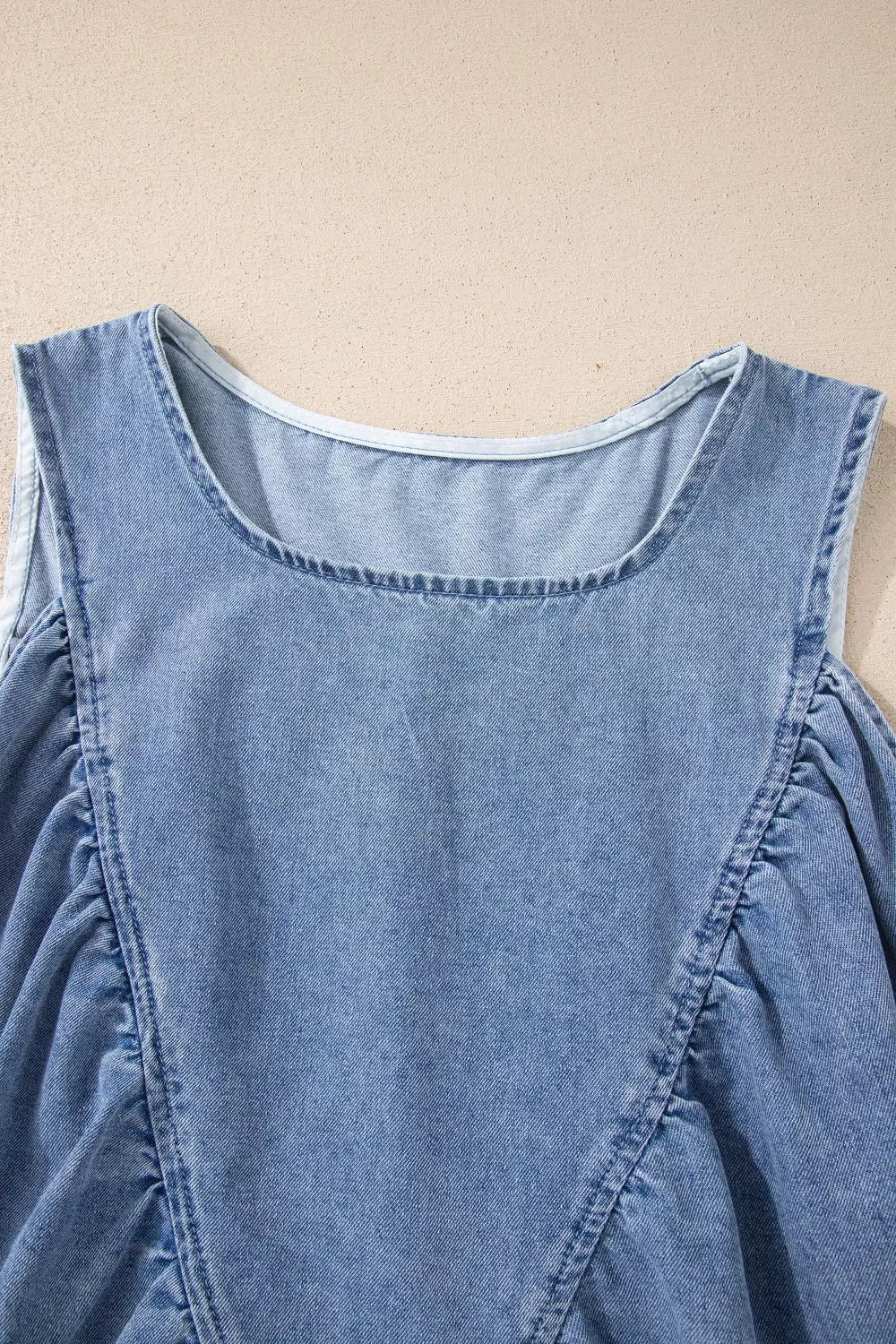 V-neck pleated denim sleeveless top with a casual cut.