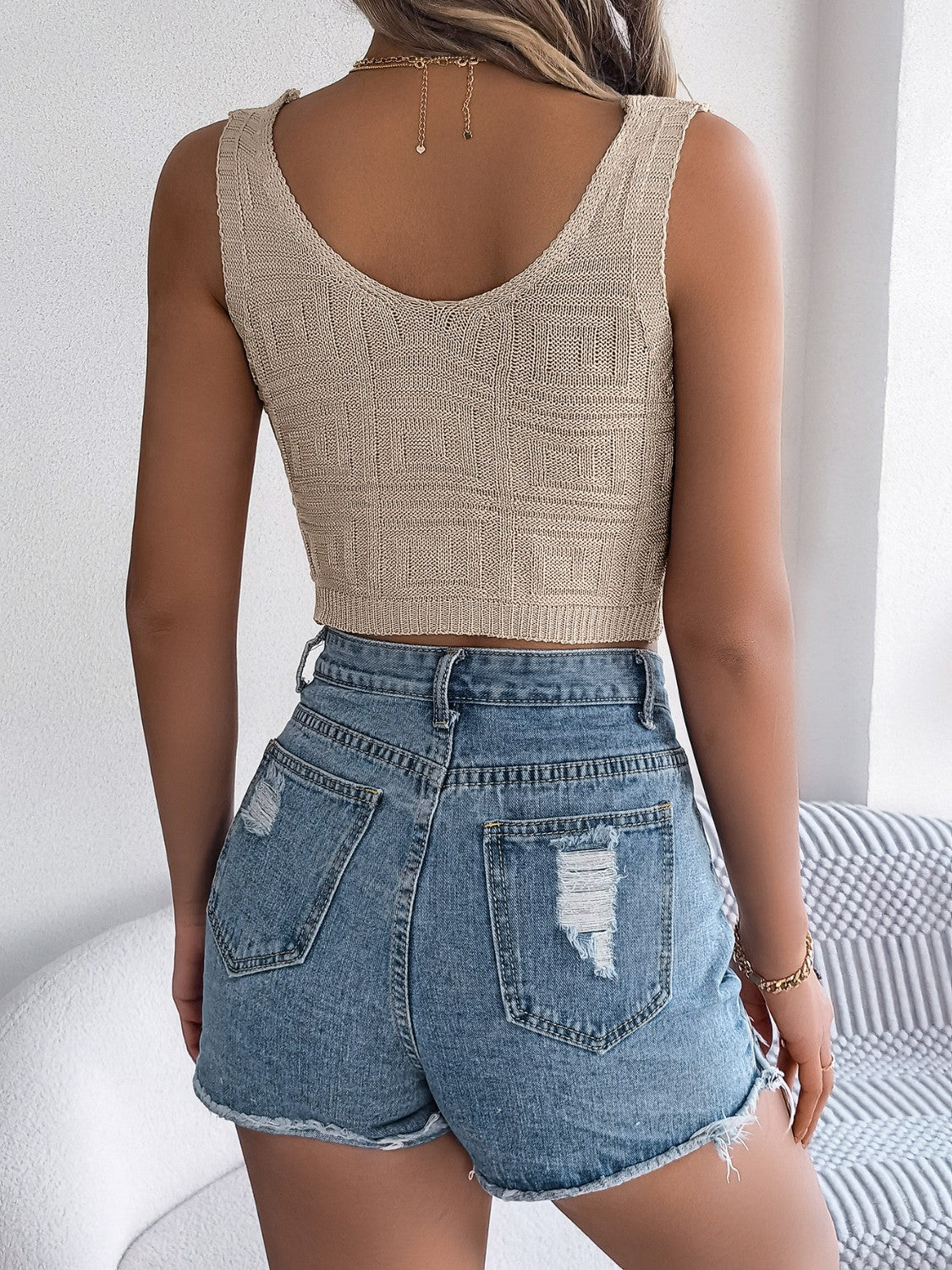 Khaki knit crop top with textured pattern and scoop neck, paired with distressed denim shorts.
