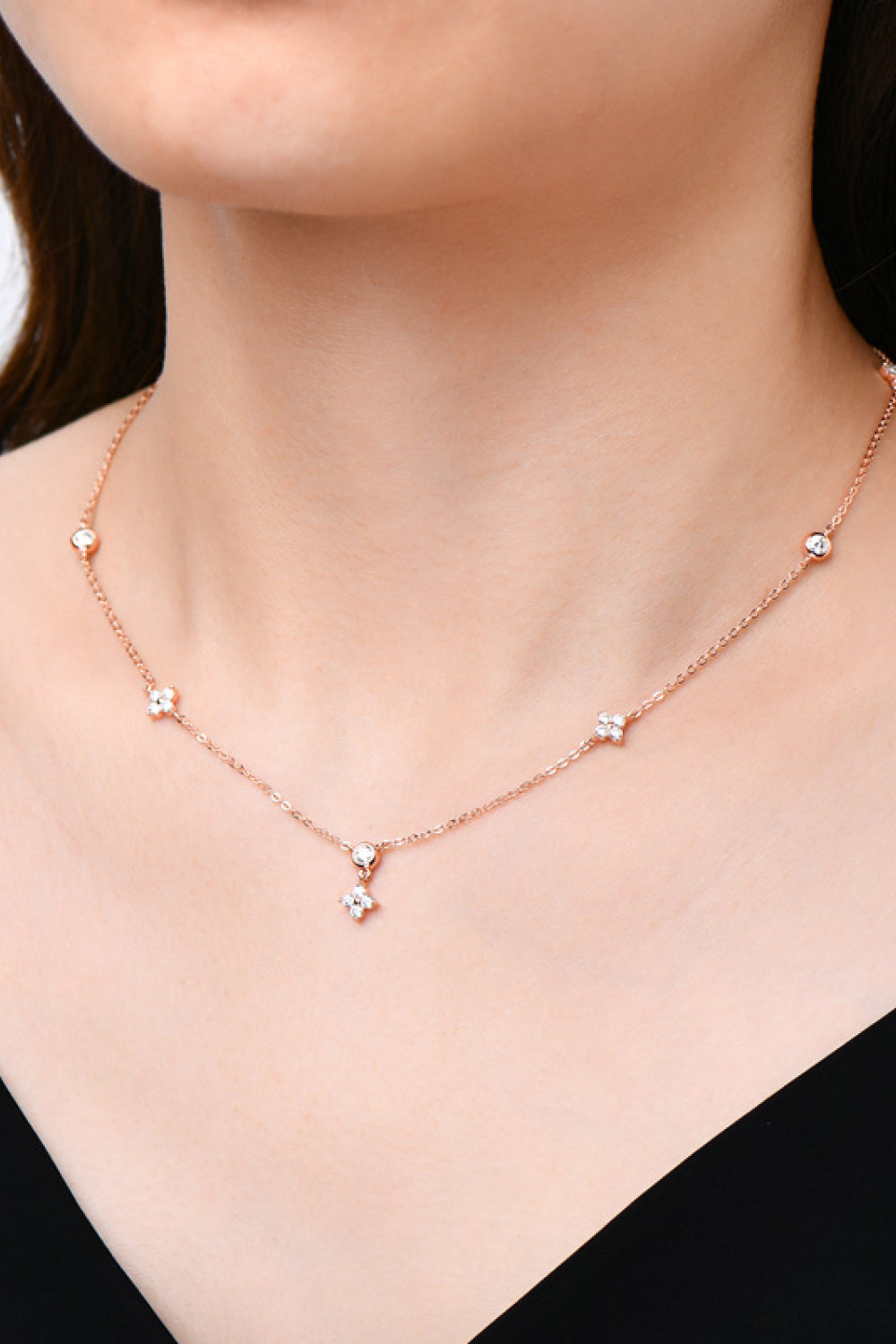 Rose gold necklace with scattered diamond clusters and a central dangling cluster.