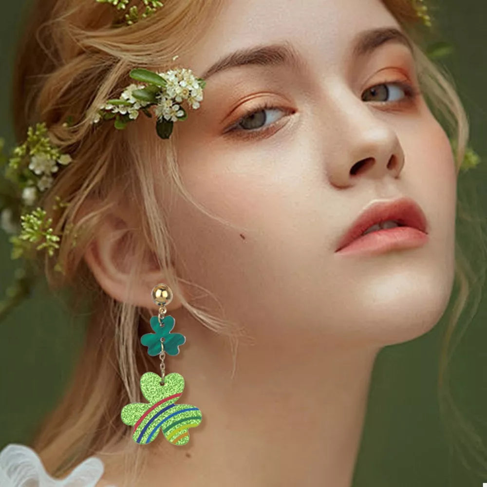 Gold dangle earrings with green clover charms and colorful stripes