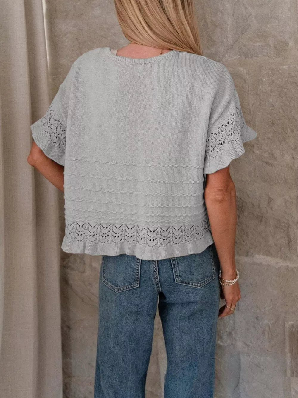 Grey knit top with crew neck, short sleeves, and delicate lace trim at hem and cuffs.