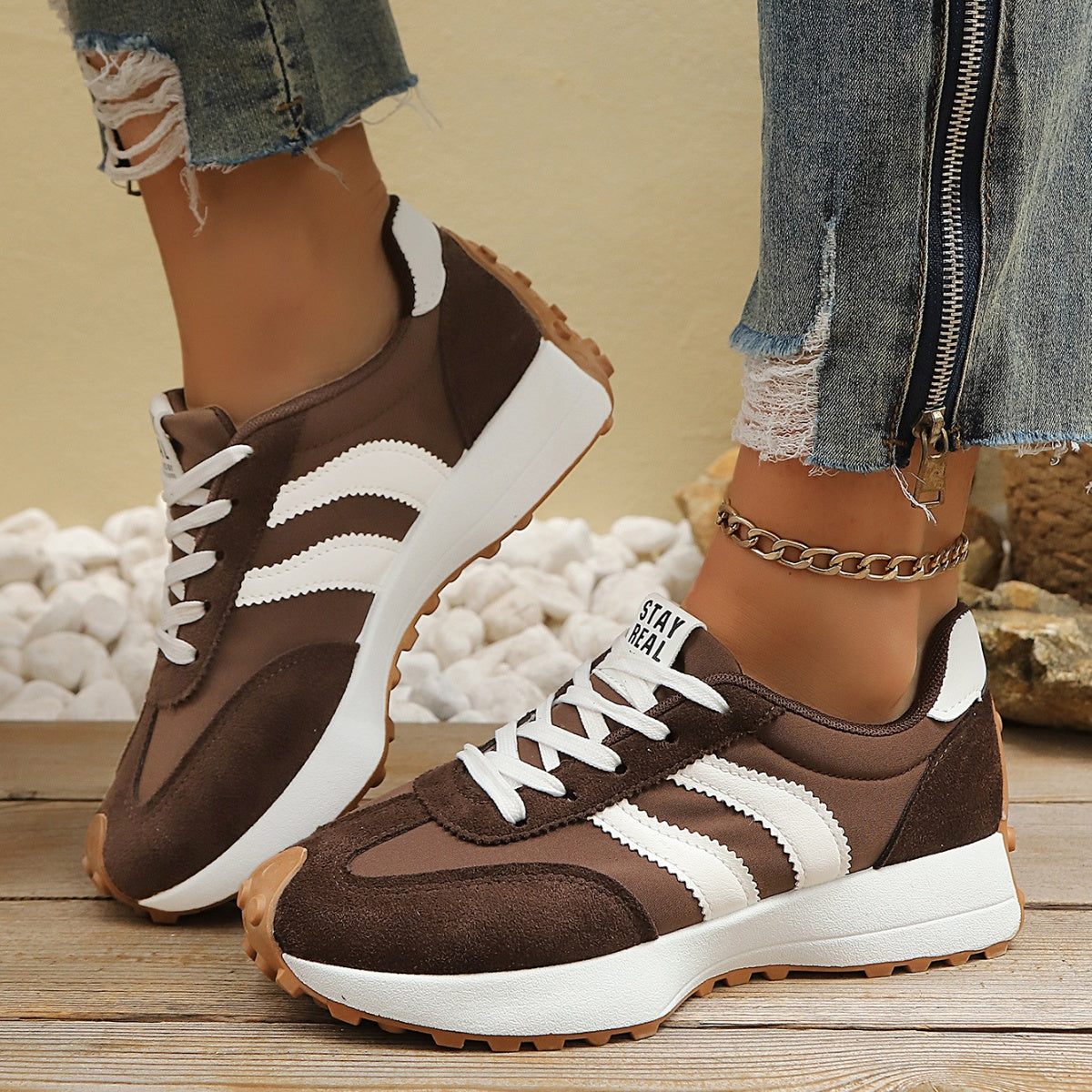 Brown lace up round toe sneakers with white stripes and chunky sole.