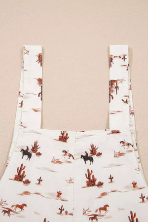 White cotton jumpsuit with desert motif, cowboys, horses, and cacti pattern.