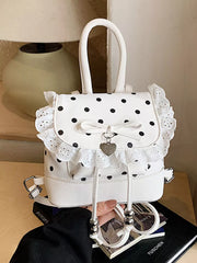 Charming polka dot lace mini backpack in cream white with bow detail and heart charm.