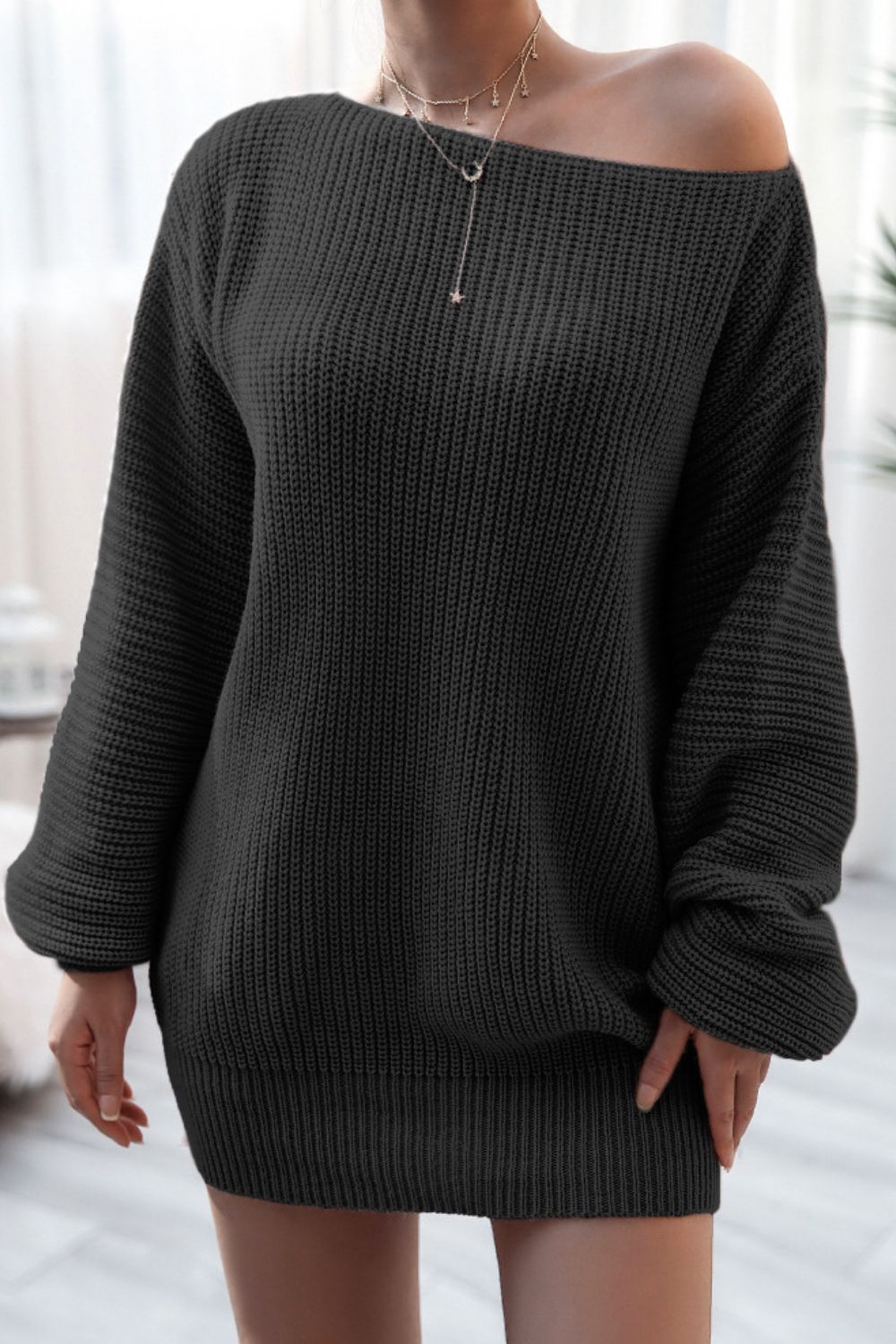 Black ribbed knit off-the-shoulder mini dress with long sleeves.