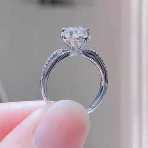 Brilliant moissanite ring in sterling silver with pavé band.