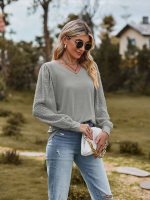 Gray V-neck blouse with Swiss dot puff sleeves and a relaxed fit.