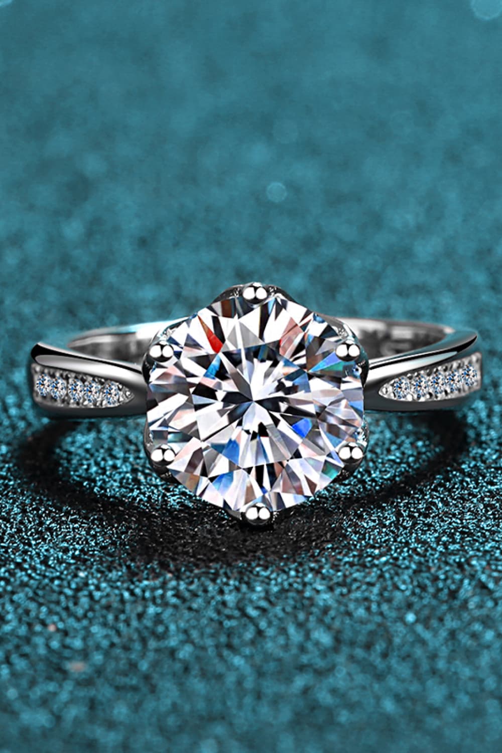 Silver ring with large round moissanite center stone and pavé band.